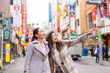 © CandyRetriever  - Asian woman friends shopping together at Shibuya district, Tokyo, Japan with crowd of people walking in the city. Attractive girl enjoy and fun outdoor lifestyle travel city in autumn holiday vacation