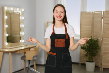 Wall Mural - Portrait of professional hairdresser wearing apron in beauty salon