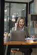 © SOMKID - Happy excited young successful business woman and working online at the table in office, Asian business woman.