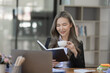 © SOMKID - Cheerful asian businesswoman working at table office.