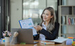 © SOMKID - Cheerful asian businesswoman working at table office.