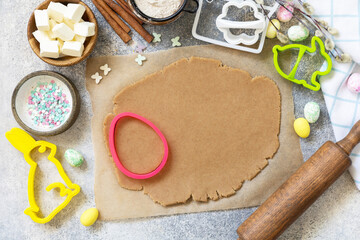 Wall Mural - Easter baking ingredients background. Flour, eggs, milk, sugar, butter and kitchen utensils for baking on a stone table. View from above.