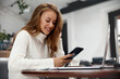 © verona_studio - Image of beautiful  woman smiling and using cellphone. Girl working with laptop.