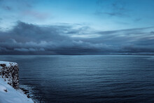Iceland Cloudy Stormy Blue Sky Over The Ocean With Coastline After Sunset