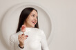 © primipil - Indoor portrait of positive smiling brunette young woman on white background holding sweet dessert cake in hands.