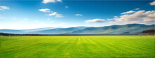 Panoramic Natural Landscape With Green Grass Field, Blue Sky With Clouds And And Mountains In Background. Panorama Summer Spring Meadow. Shallow Depth Of Field.