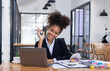 © SOMKID - Young African American businesswoman working with pile of documents at office workplace, business finance and accounting concepts.
