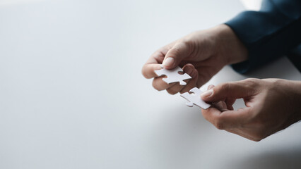 man holding two jigsaw puzzles put together, business management concept and business risk managemen