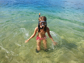 child dives into clear water and admires the beautiful underwater nature 