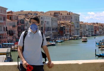 Wall Mural - man tourist in venice in ITALY with face mask on the Rialto Bridge