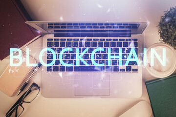 Poster - Blockchain theme hologram drawings over computer on the desktop background. Top view. Double exposure.