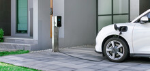 Progressive Concept Of EV Car And Home Charging Station Powered By Sustainable And Clean Energy With Zero CO2 Emission For Green Environmental. Charging Point At Residential Area For Electric Vehicle.