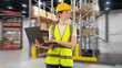 © Grispb - Woman fulfillment worker. Manager with laptop stands in warehouse building. Girl is specialist in logistics company. Woman in warehouse worker uniform. Lady with laptop computer in logistics center