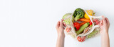 Fototapeta Kawa jest smaczna - Female hands take out fresh vegetables from a bag on a white background. Top view, flat lay. Banner