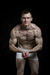 © Anna Shelestova - Handsome muscular guy in underwear. The photo was taken in a studio on a dark background.