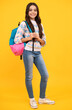 Back to school. Teenage school girl ready to learn. School children on yellow isolated background.
