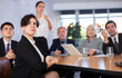 © JackF - Office coworkers of different ages watching presentation while sitting at table with laptop and notes