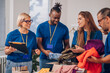 © Zamrznuti tonovi - Diverse volunteers working in a charity donation center and packing clothes and food