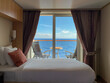 Cruise ship stateroom suite open to a balcony overlooking the beautiful blue ocean
