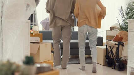 Wall Mural - Young Asian couple help each other moving carton box full of stuff get some rest sit on sofa couch in living room at new house. Husband and wife move new house, Apartment Rent And Ownership Concept.