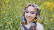 © Довидович Михаил - A young girl poses in a rapeseed field with a beautiful hairdo of flowers and butterflies.