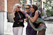 © Anna Zhukkova - Three happy female friends talking and laughing, having fun and cuddling outside. Lifestyle mature women portrait on city street
