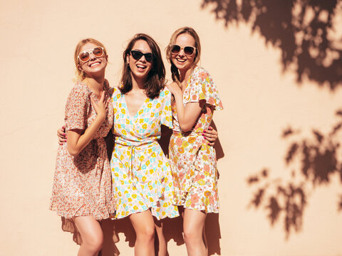 three young beautiful smiling hipster female in trendy summer dress clothes. sexy carefree women pos