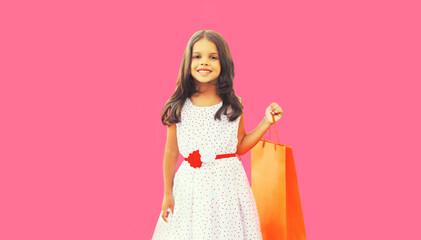 Wall Mural - Portrait of little girl child with shopping bags on pink background