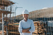 © Westend61 - Happy mature architect with arms crossed in construction area