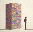 © Westend61 - Illustration of businesswoman standing in front of tangled block representing complex challenge