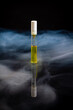 Vertical shot of perfume sample bottle with steam. Isolated on black.