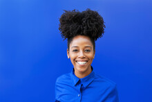 Happy Young Woman With Afro Hairstyle Against Colored Background