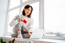 Happy Beautiful Woman Shopping Online With Credit Card Through Laptop