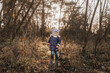 © Cavan Images - Small happy boy standing in forest during autumn time