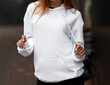 © AlexGo - Woman in hoodie sweater on street background. Space for print design logo