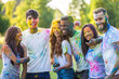 © oneinchpunch - Multiethnic group of happy playful friends playing and having fun with holi colorful powder at the park