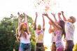© oneinchpunch - Multiethnic group of happy playful friends playing and having fun with holi colorful powder at the park