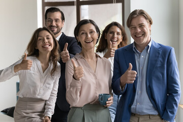 Wall Mural - Happy successful diverse business team celebrating achieve, good teamwork result, success, smiling, laughing, looking at camera, showing thumb up, like approve hand gesture