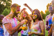 © oneinchpunch - Multiethnic group of happy playful friends playing and having fun with holi colorful powder at the park