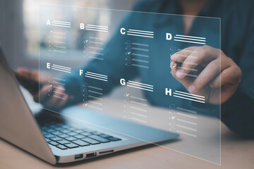 Businessman using a laptop and Taking an assessment, questionnaire, evaluation, online survey online exam Choosing the right answer in exam by filling out the online survey form,Answer  test questions
