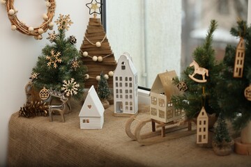 Poster - Beautiful window sill decorated for Christmas with small houses and fir trees indoors