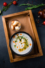 Sticker - Champignon cream soup in a bowl served with green peas and oil.