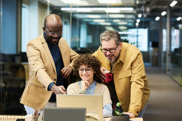 Poster - Confident African American businessman explaining graphic data on laptop screen to colleagues while making presentation