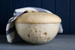Bowl of fresh yeast dough on grey wooden table