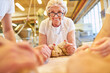 © Robert Kneschke - Ältere Frau als Senior Chefin beim Teig kneten in Bäckerei
