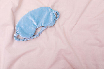 Poster - Light blue sleep mask on beige cloth, top view. Space for text