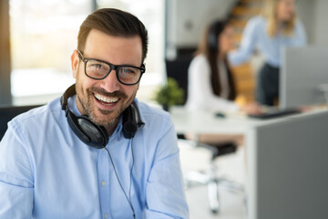 Wall Mural - Portrait of smiling operator agent with headset around his neck at office