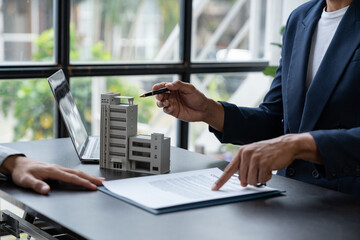 Entrepreneur, business owner, accountant, real estate agent A young Asian insurance agent explains the details of the condo purchase contract to calculate the financial risk for the client.