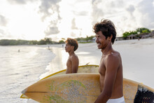 Indonesia, Lombok, Side View Of Surfers Walking Into Sea�