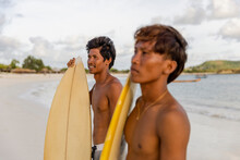 Indonesia, Lombok, Portrait Of Two Surfers Standing On Beach